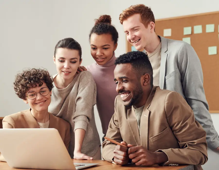 A team working together around a laptop