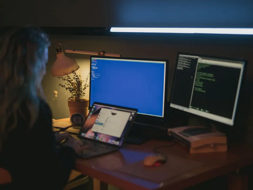 An IT specialist reviewing security information on computer screens