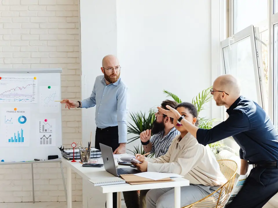 A consultant presenting an IT roadmap to a business team at a whiteboard